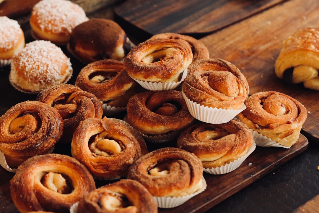 Fresh baked goods including cinnamon rolls and pastries arranged on a wooden serving board