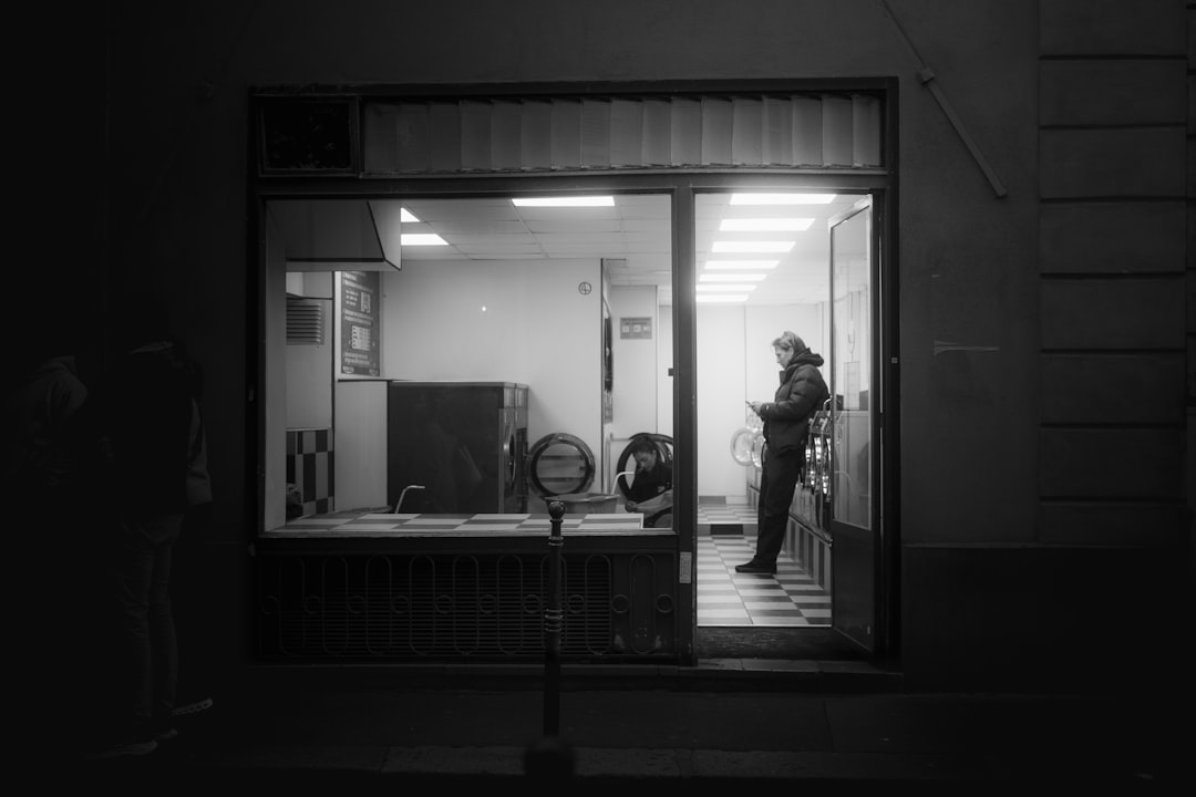 Atmospheric interior of a laundromat with rows of commercial washers and dryers shot in low light