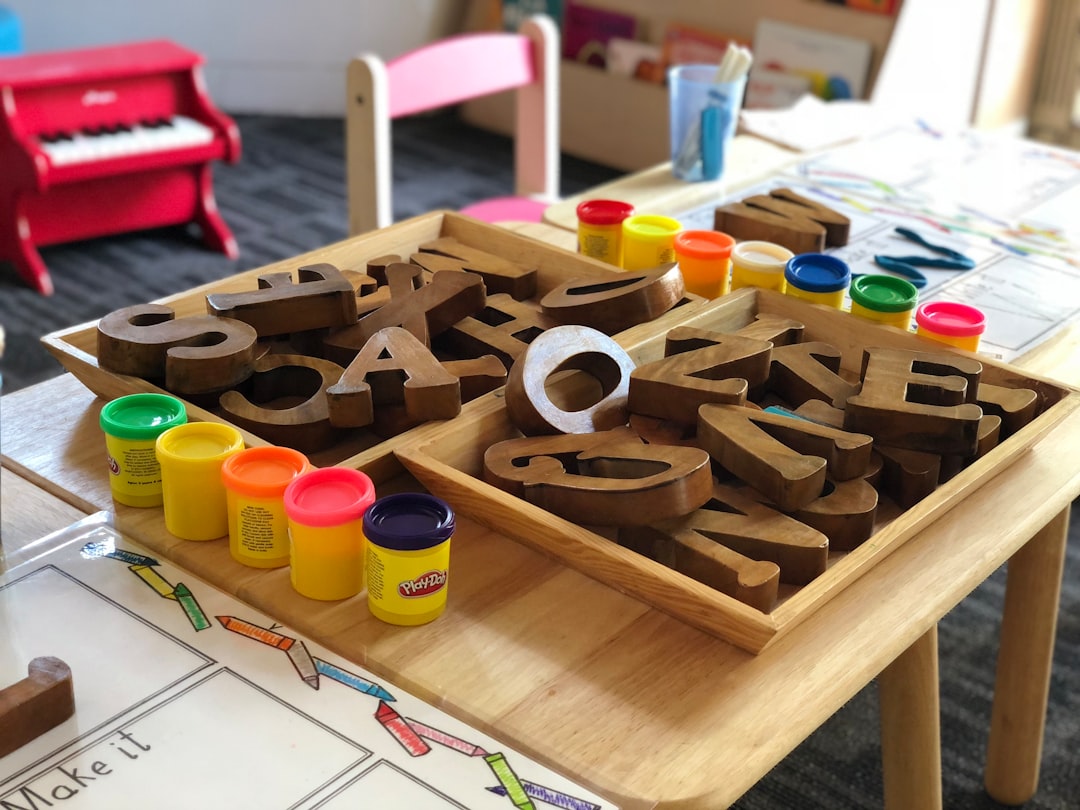 Bright preschool classroom with low wooden shelves, soft mats, and toys arranged for child accessibility